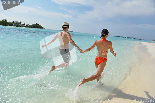 Image of happy young couple have fun on beach