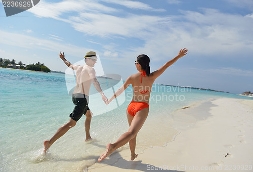 Image of happy young couple have fun on beach