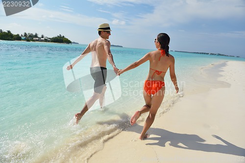 Image of happy young couple have fun on beach