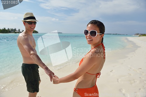 Image of happy young couple have fun on beach