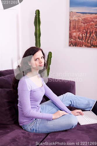 Image of smiling woman on couch with notebook