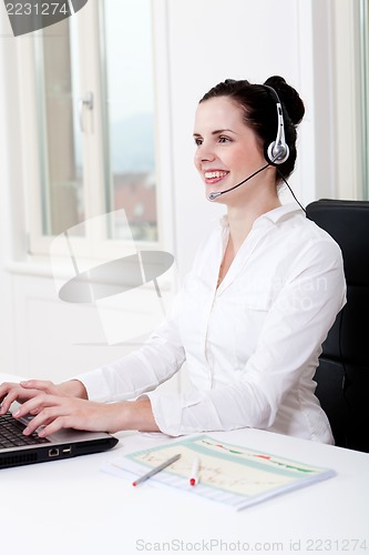 Image of smiling young female callcenter agent with headset