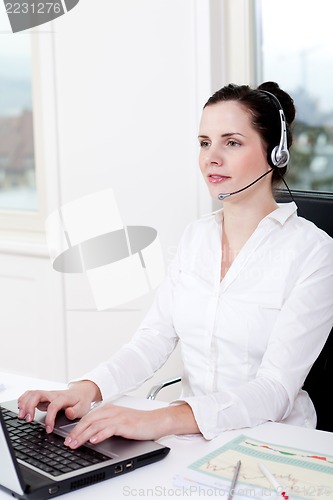 Image of smiling young female callcenter agent with headset