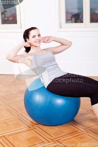 Image of attractive young woman doing sit ups 