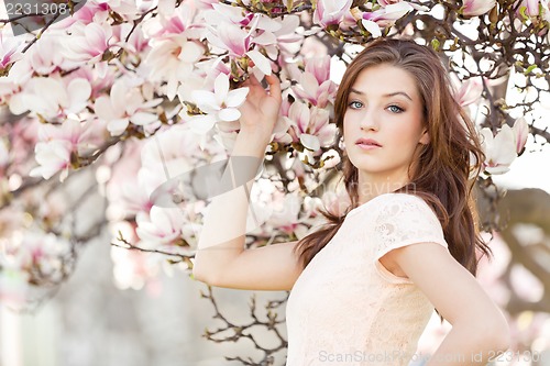 Image of beautiful young woman and pink magnolia