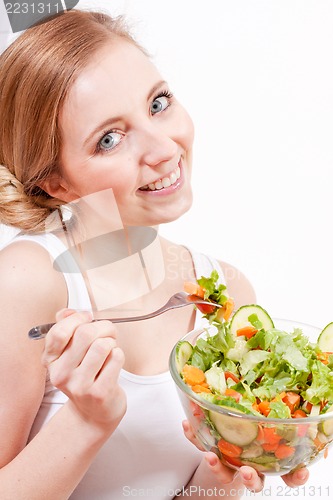 Image of smiling woman eating fresh salad