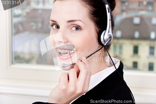 Image of smiling young female callcenter agent with headset