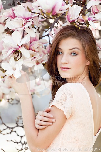 Image of beautiful young woman and pink magnolia