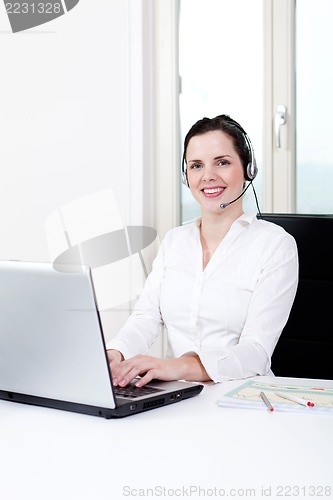 Image of smiling young female callcenter agent with headset