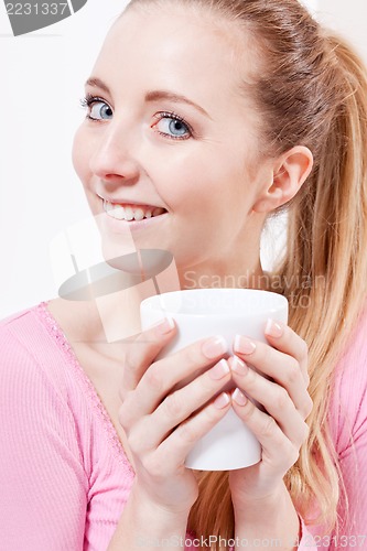 Image of smiling young blonde woman drinking coffee