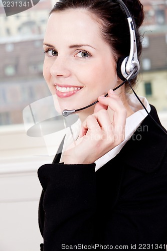 Image of smiling young female callcenter agent with headset