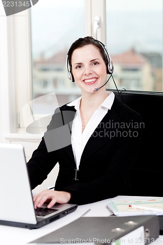 Image of smiling young female callcenter agent with headset