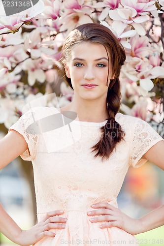 Image of beautiful young woman and pink magnolia