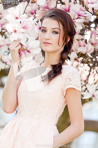 Image of beautiful young woman and pink magnolia