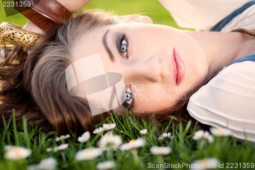 Image of beautiful woman lying in grass in summer 