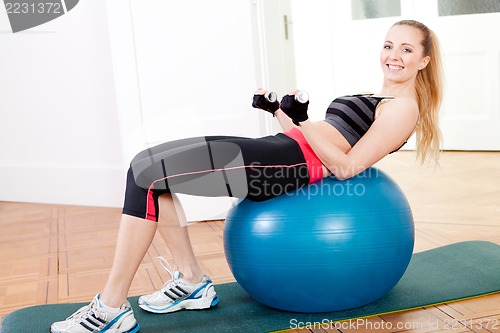 Image of attractive young woman doing fitness dumbbell