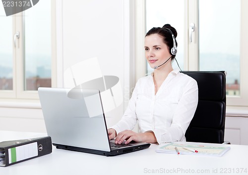 Image of smiling young female callcenter agent with headset