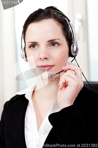 Image of smiling young female callcenter agent with headset