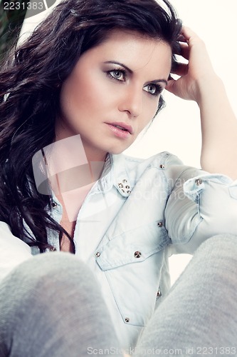 Image of attractive young woman sitting on the floor
