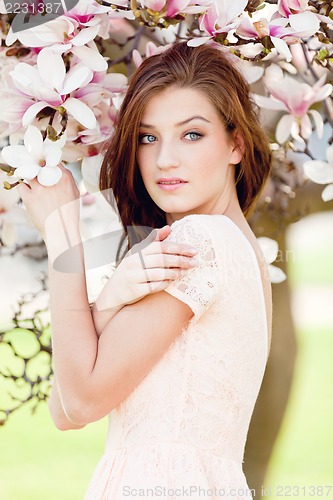 Image of beautiful young woman and pink magnolia