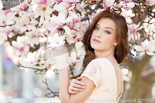 Image of beautiful young woman and pink magnolia