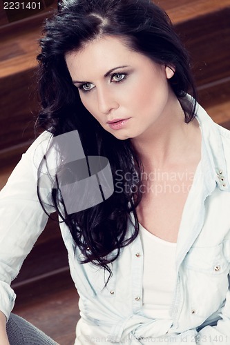 Image of attractive young woman sitting on the floor