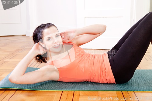 Image of attractive young woman doing sit ups 