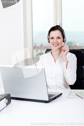 Image of smiling young female callcenter agent with headset