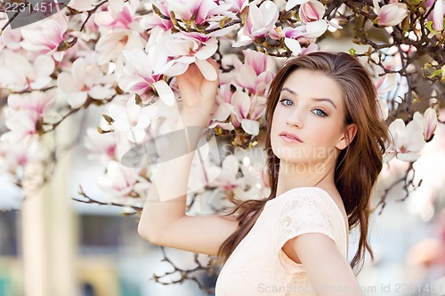 Image of beautiful young woman and pink magnolia