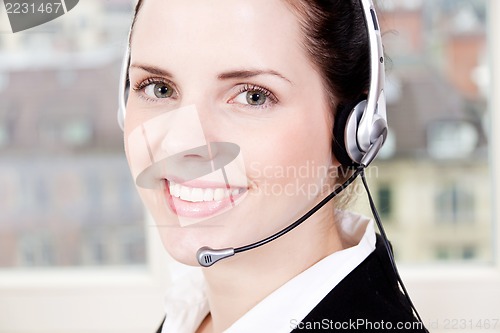 Image of smiling young female callcenter agent with headset