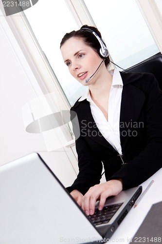 Image of smiling young female callcenter agent with headset