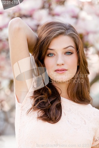 Image of beautiful young woman and pink magnolia