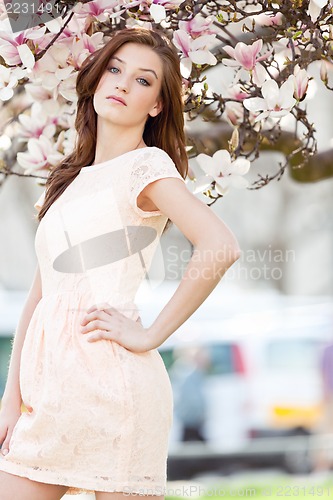 Image of beautiful young woman and pink magnolia