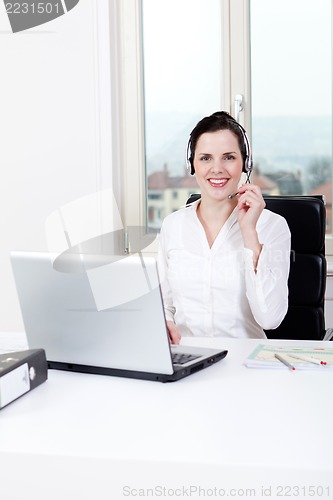 Image of smiling young female callcenter agent with headset