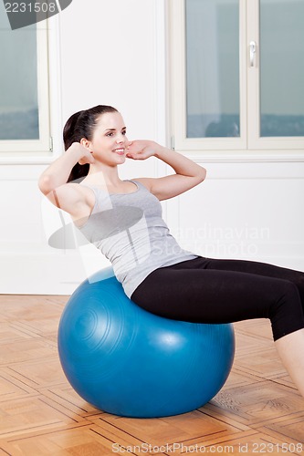 Image of attractive young woman doing sit ups 