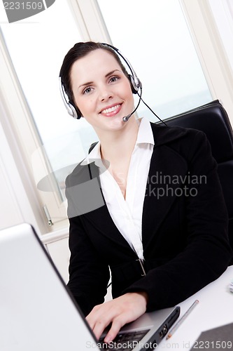 Image of smiling young female callcenter agent with headset