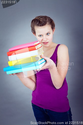 Image of Silly smiling schoolgirl with glasses and lots of books