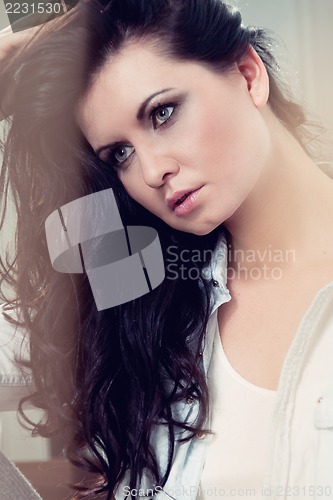 Image of attractive young woman sitting on the floor