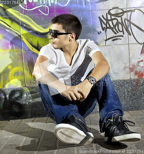 Image of man in front of graffiti wall