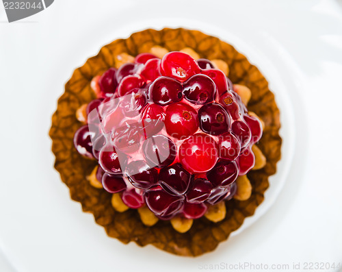 Image of Cake with a cranberry on a white plate, a close up