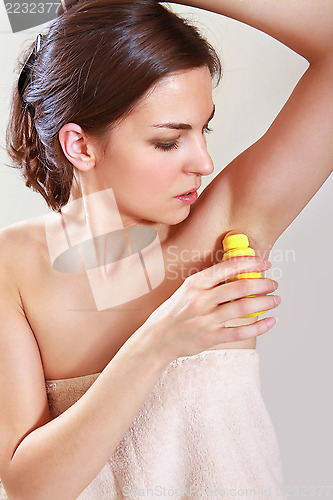 Image of woman applying deodorant