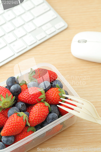 Image of Healthy lunch box with strawberry and blueberry mix in office