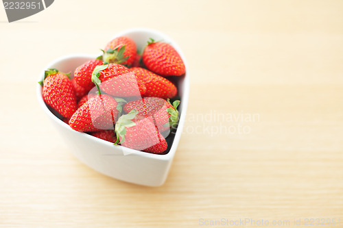 Image of Strawberry in heart shape bowl on wooden background