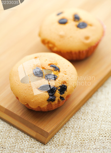 Image of Small cupcake on wooden plate 