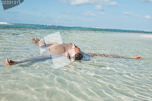 Image of Man floating in water on the beach