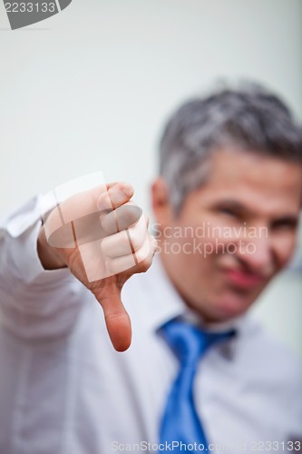 Image of Businessman gesturing thumbs down sign