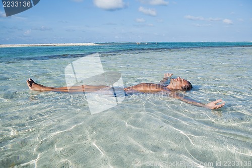 Image of Man floating in water on the beach