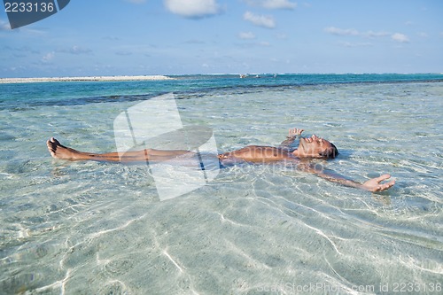 Image of Man floating in water on the beach