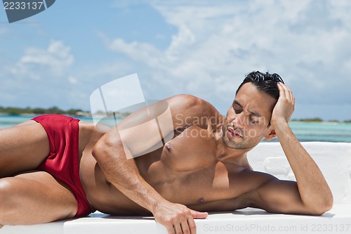 Image of Man sunbathing on the beach