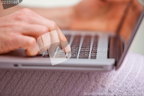 Image of Mid section view of a man using a laptop